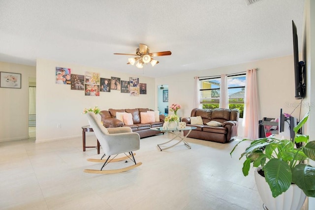 living room with a textured ceiling and ceiling fan