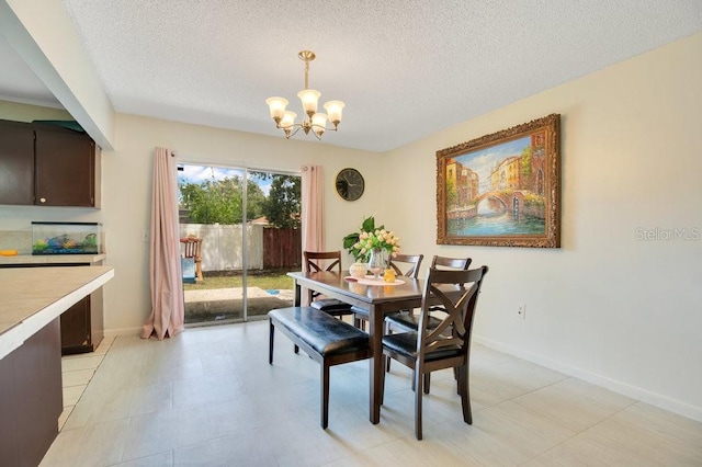 tiled dining room featuring an inviting chandelier and a textured ceiling