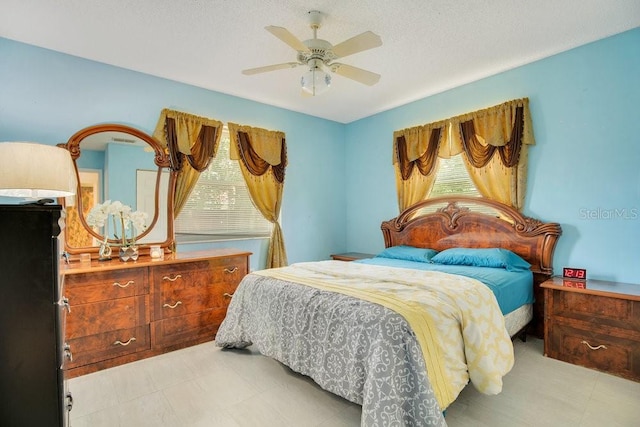 bedroom with ceiling fan, a textured ceiling, and multiple windows