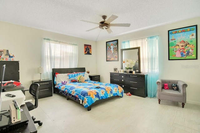 bedroom with ceiling fan and a textured ceiling