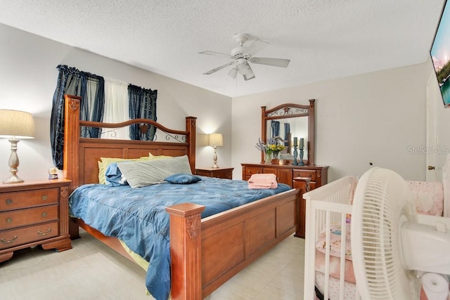 bedroom featuring ceiling fan and a textured ceiling