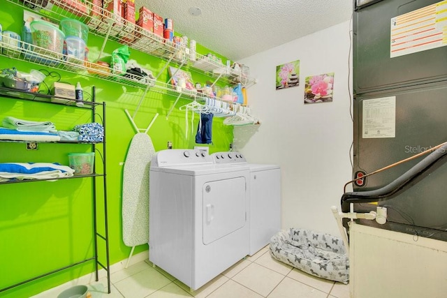 laundry area featuring light tile patterned floors, a textured ceiling, heating unit, and washer and dryer