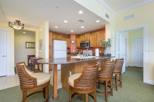 kitchen featuring white appliances, kitchen peninsula, crown molding, sink, and light colored carpet