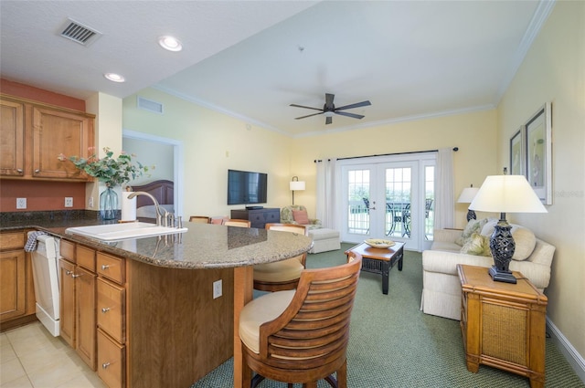 kitchen with ornamental molding, dishwasher, light colored carpet, and sink