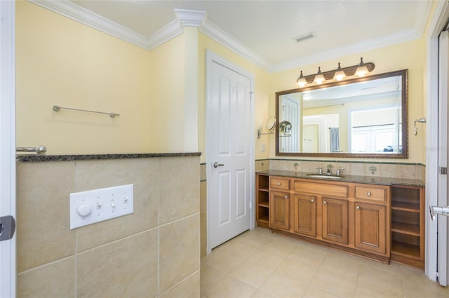 bathroom with ornamental molding, vanity, and tile walls