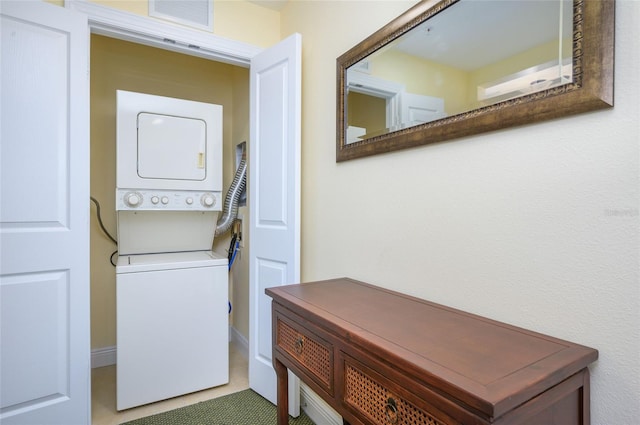 clothes washing area featuring stacked washer and dryer