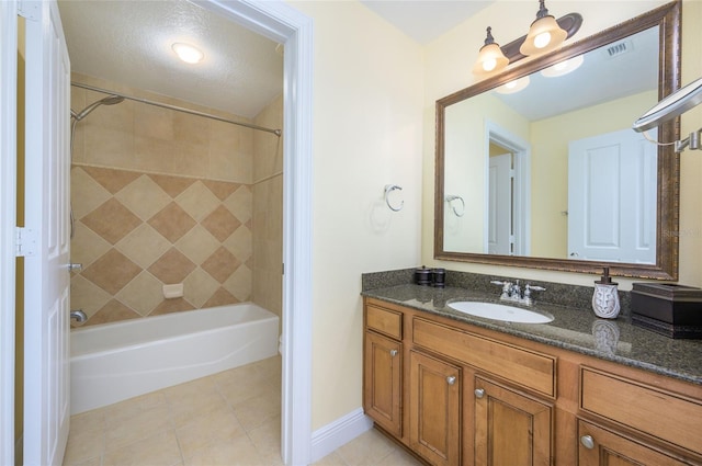 bathroom featuring tiled shower / bath, vanity, a textured ceiling, and tile patterned floors