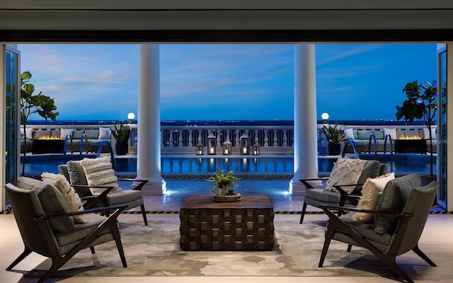 patio terrace at dusk featuring pool water feature