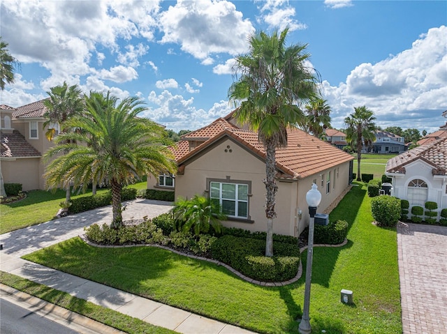 mediterranean / spanish-style home with a garage and a front lawn