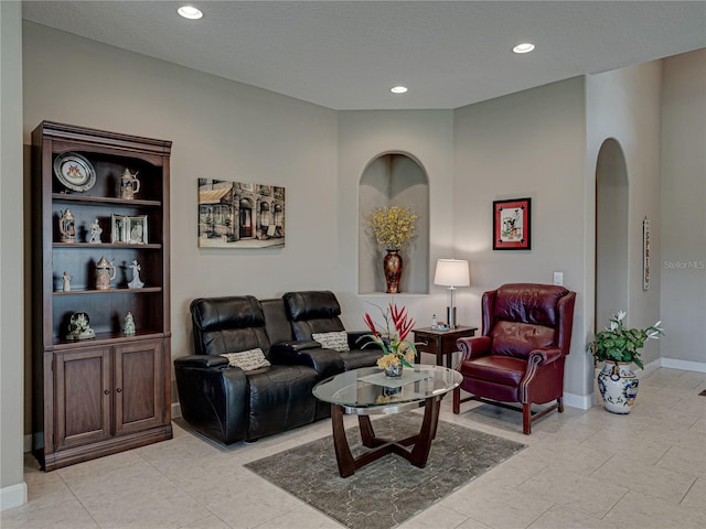 living room featuring a textured ceiling and light tile patterned flooring