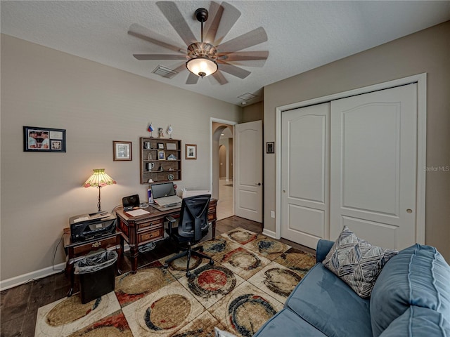 office space with a textured ceiling, dark hardwood / wood-style flooring, and ceiling fan