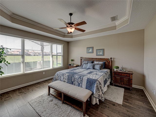 bedroom featuring a tray ceiling, multiple windows, ceiling fan, and crown molding