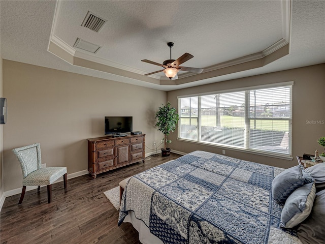 bedroom featuring ornamental molding, a tray ceiling, ceiling fan, and dark wood-type flooring