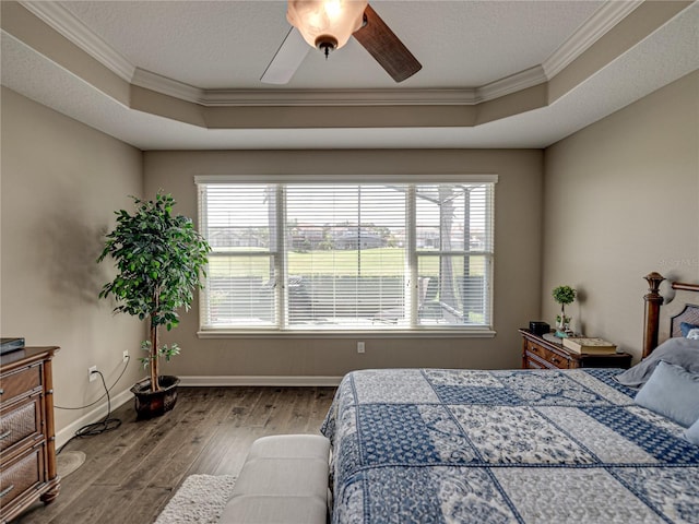 bedroom featuring multiple windows, ornamental molding, ceiling fan, and hardwood / wood-style flooring