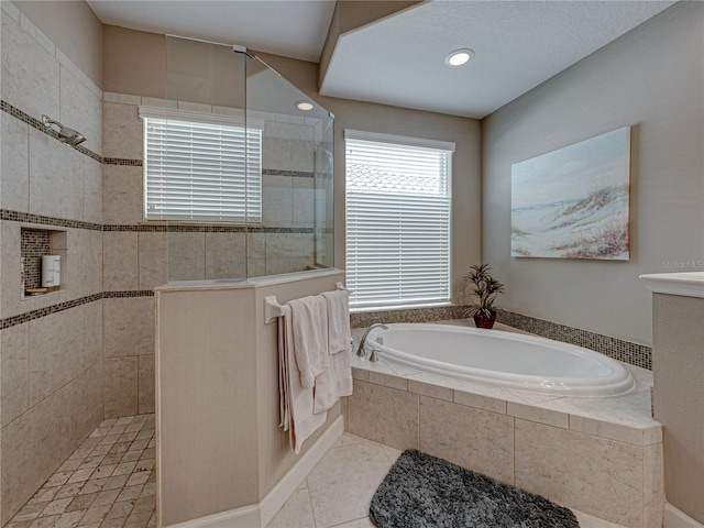 bathroom featuring a textured ceiling, plus walk in shower, and tile patterned floors