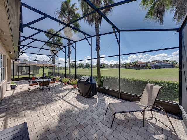 view of patio / terrace with glass enclosure and a grill