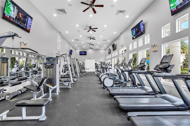 workout area with a towering ceiling and ceiling fan