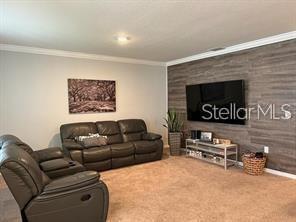 carpeted living room featuring crown molding