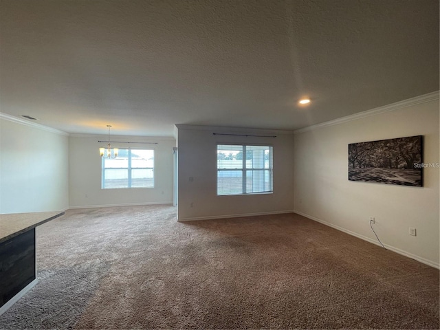 carpeted empty room with a textured ceiling, crown molding, and a chandelier