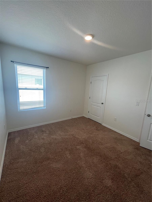 carpeted spare room with a textured ceiling