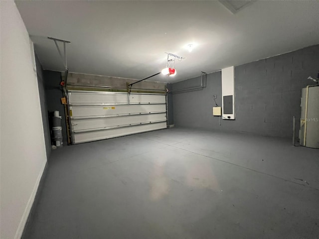 garage with gas water heater, electric panel, and a garage door opener