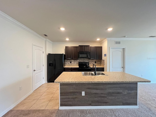 kitchen with a center island with sink, black appliances, sink, and light tile patterned floors