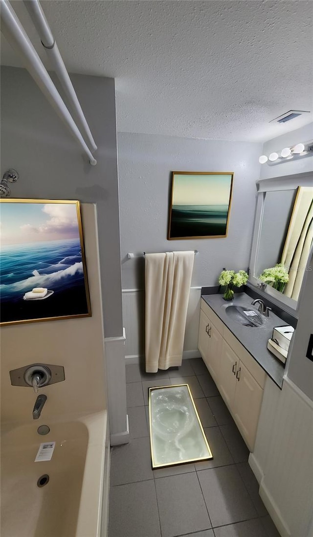 bathroom with tile patterned floors, vanity, and a textured ceiling