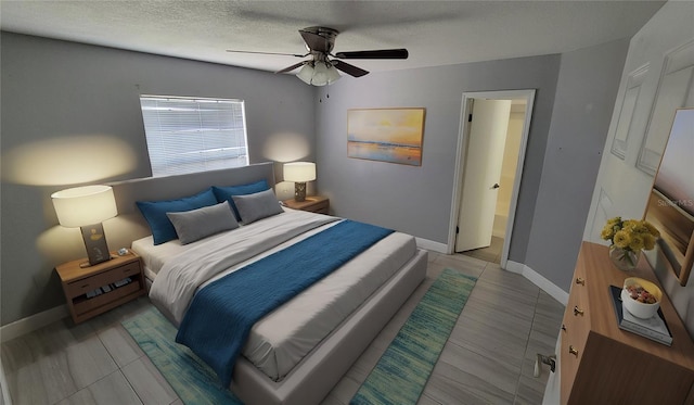 bedroom featuring ceiling fan and a textured ceiling