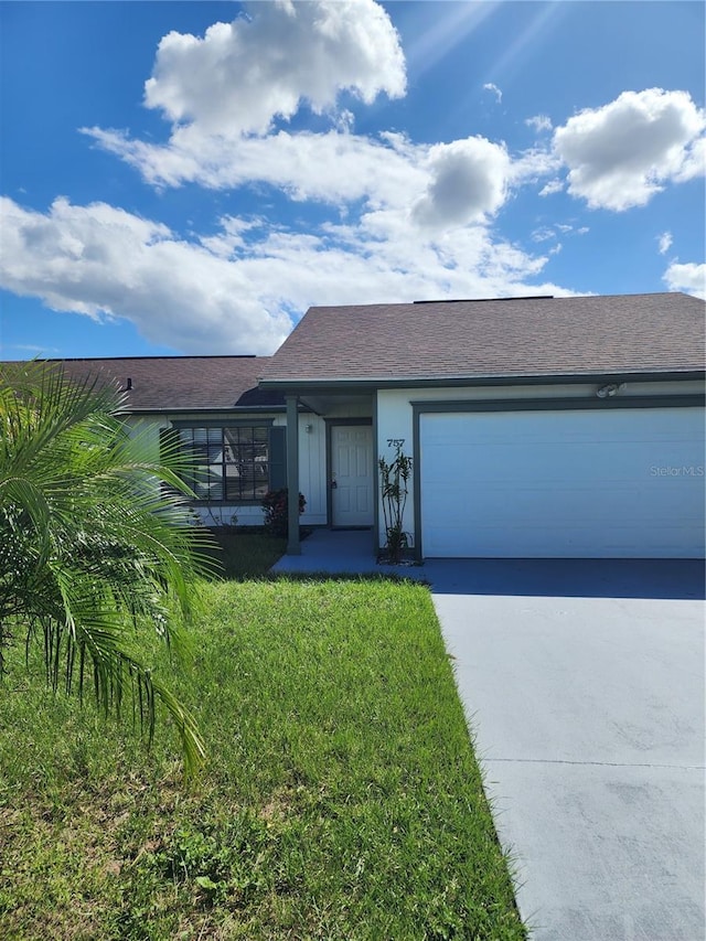 view of front of property with a garage and a front lawn