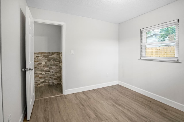 empty room featuring a textured ceiling and hardwood / wood-style flooring