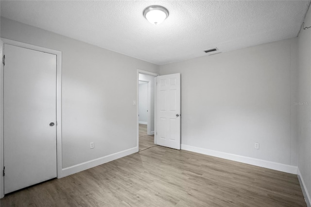 unfurnished bedroom featuring a textured ceiling and light wood-type flooring