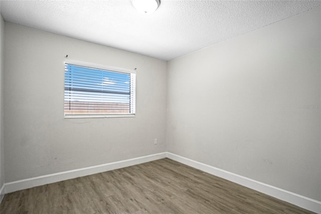 spare room featuring wood-type flooring