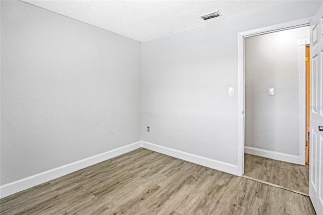 unfurnished room with hardwood / wood-style flooring