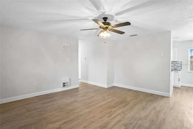 spare room featuring ceiling fan, a textured ceiling, and light wood-type flooring