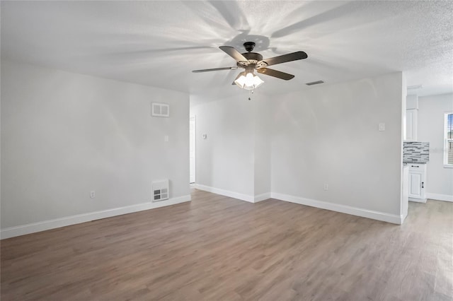 unfurnished room with ceiling fan, a textured ceiling, and light hardwood / wood-style floors