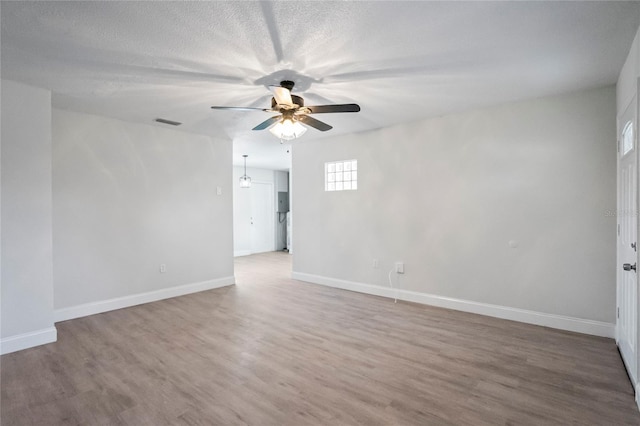 unfurnished room with wood-type flooring, ceiling fan, and a textured ceiling