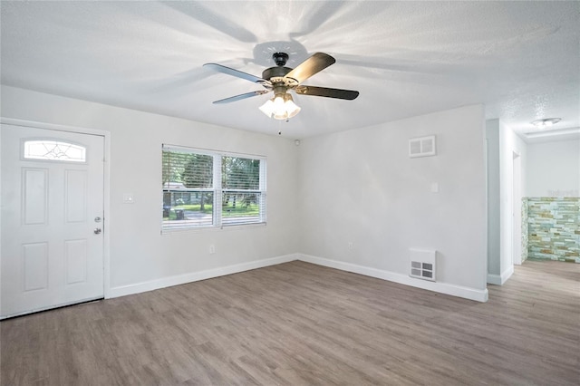 entryway with ceiling fan, hardwood / wood-style flooring, and a textured ceiling