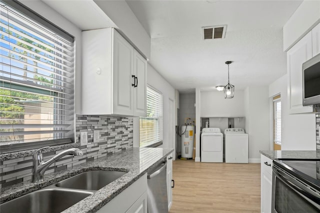 kitchen featuring a wealth of natural light, white cabinetry, and appliances with stainless steel finishes