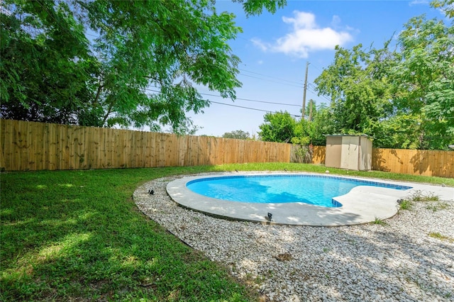 view of pool with a shed and a yard