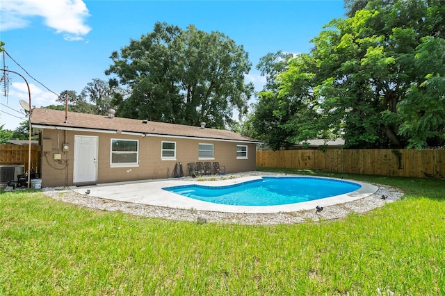 view of pool featuring a patio, central AC unit, and a yard