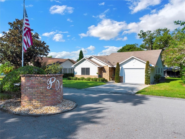 ranch-style house featuring a front lawn, central air condition unit, and a garage