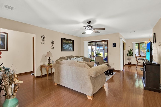 living room with ceiling fan and dark wood-type flooring