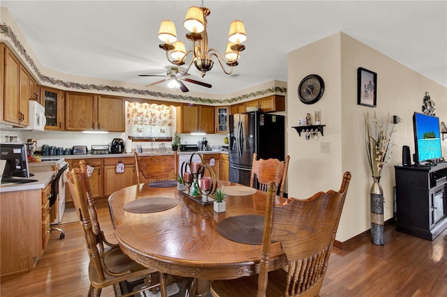 dining room featuring sink, ceiling fan with notable chandelier, and dark hardwood / wood-style flooring