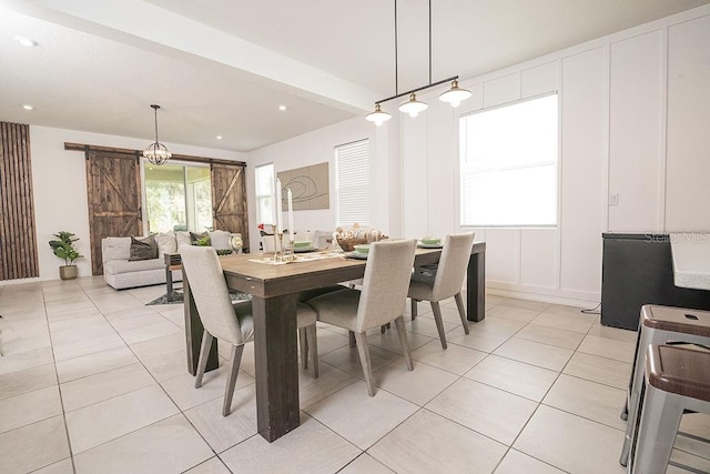 dining area featuring a barn door and light tile patterned floors