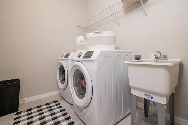 laundry room with independent washer and dryer and light tile patterned floors