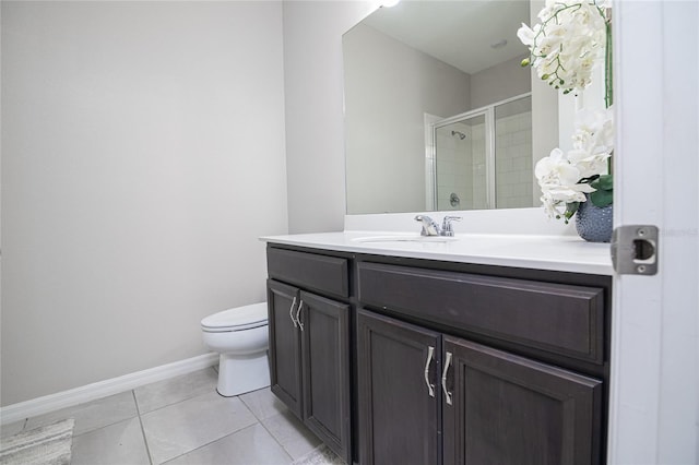 bathroom featuring toilet, vanity, tile patterned floors, and a shower with shower door