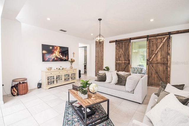 tiled living room featuring a barn door and an inviting chandelier