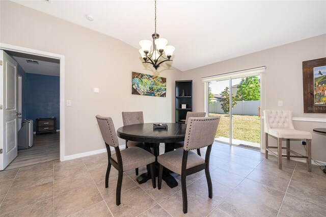 dining room with a notable chandelier and vaulted ceiling