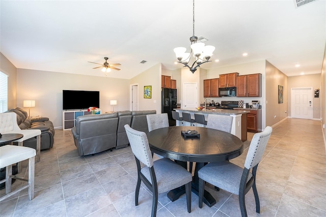 dining area with ceiling fan with notable chandelier and sink