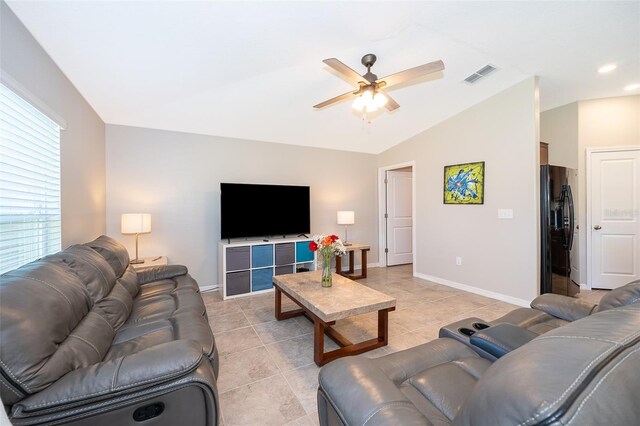 living room featuring ceiling fan, lofted ceiling, and light tile patterned floors